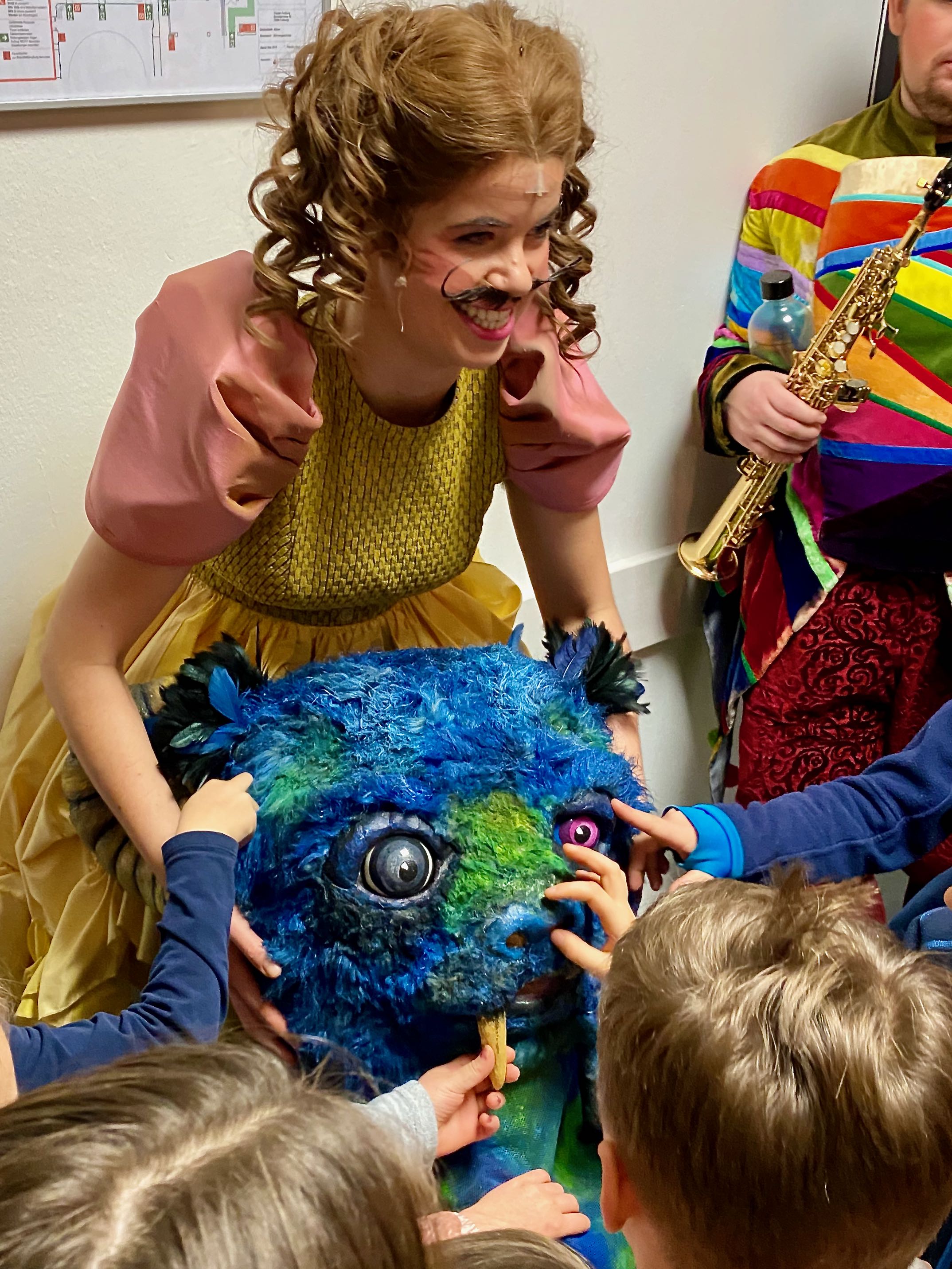 Andrea Spicher zeigt den Kindern die Maske des Untiers